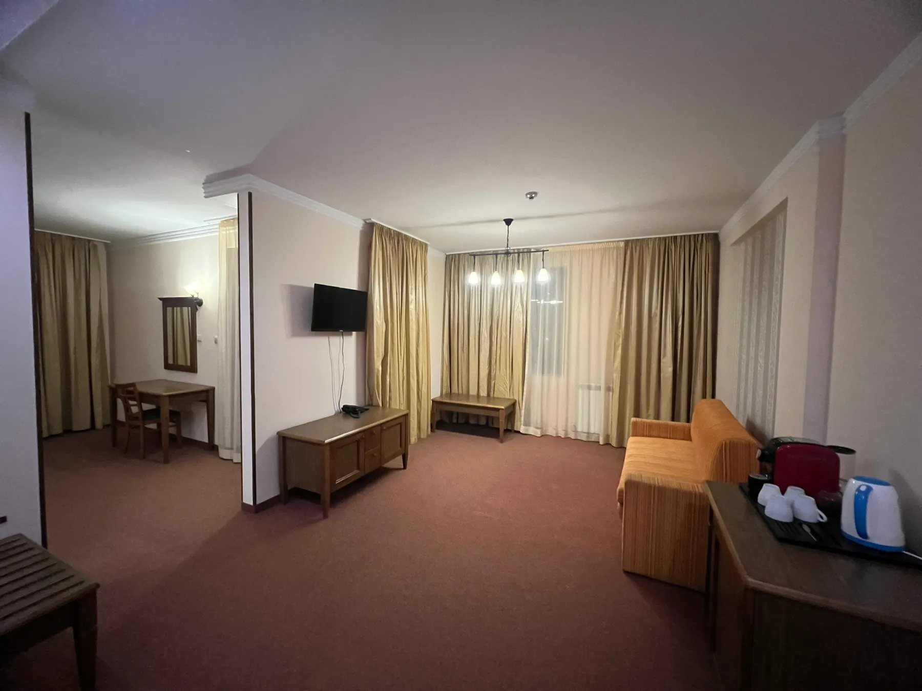 Junior Suite — дневната с разтегателен диван, телевизор и полилей
